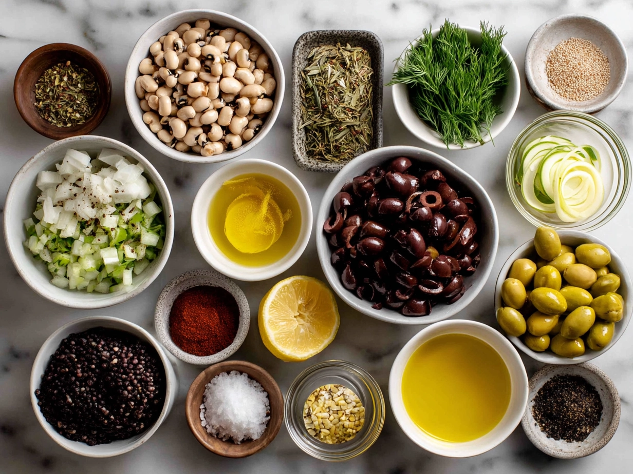 Top down view of raw ingredients for Olive Salad with Black Eyed Peas including black eyed peas, chopped olives, bell peppers, parsley, and spices on marble surface
